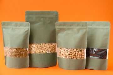 Bags with different groats on color background