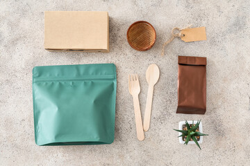 Packages for food and cutlery on grey background