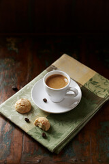 Obraz premium Cup of coffee with amaretti (Italian biscuits) on rustic wooden background. 