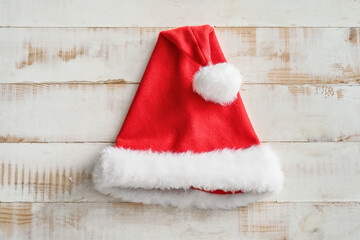 Obraz na płótnie Canvas Santa Claus hat on white wooden background