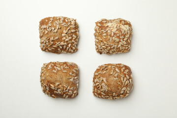 Fresh baked buns with sunflower seeds on white background