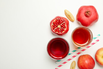 Glasses with apple and pomegranate juices on white background