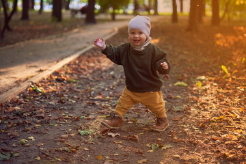one and a half year old child running in the park in autumn