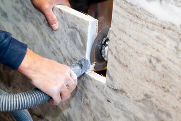 artisan cuts edges in marble kitchen countertop with hand circular saw