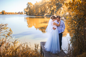 newlyweds are hugs on the shore of a picturesque lake