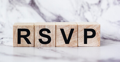 The abbreviation rsvp request for a response from an invited person is written on wooden blocks