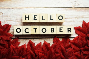 Happy October alphabet letter with red maple leaves decoration on wooden background