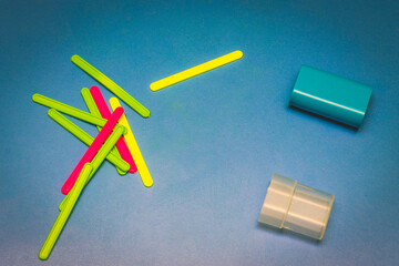 Multi-colored counting sticks lie on a blue rough table with a case. High quality photo