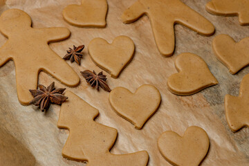 Gingerbread cookies of various shapes on baking paper. Handmade homemade cookies.