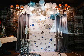 Birthday Cake on a background blue, white and silver balloons, brick wall. Baby shower party,...