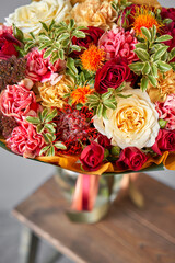 Autumn, Red tones Beautiful bouquet of mixed flowers in womans hands. the work of the florist at a flower shop. Handsome fresh bouquet. Flowers delivery