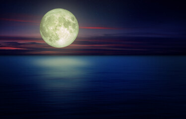 Full Moon with dark cloud in night sky and seascape view in background. (Elements of this image furnished by NASA.)