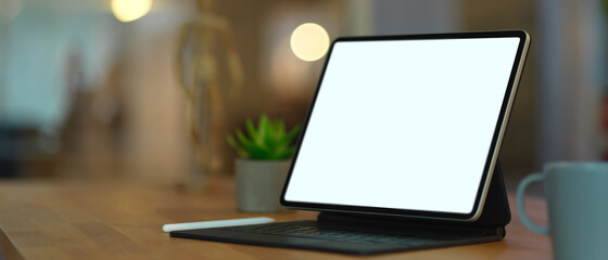 Mock up digital tablet on wooden table in blurred background