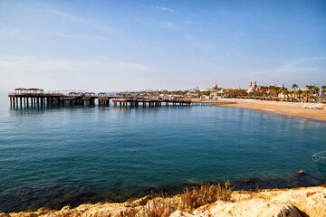 Obraz premium Rocky coast, sea, sky and pier in the background