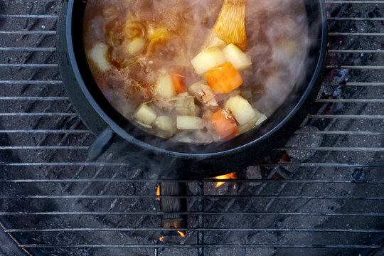 Stew Cooked On Fire Outdoors In A Cast-iron Pot, Overhead Shot