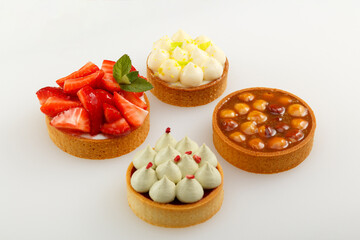Set of four mini tart with raspberry berries, cream and hazelnut