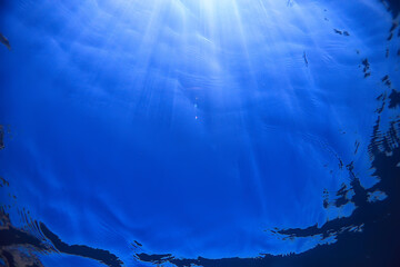 ocean water blue background underwater rays sun / abstract blue background nature water