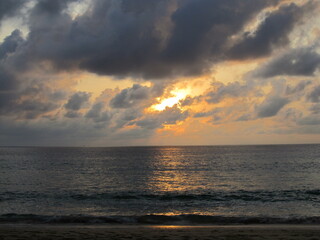 Dramatic sunset sky with clouds over ocean.