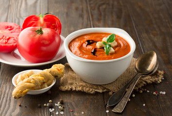 Tomato and fresh basil soup with garlic, cracked papper corns, served with cream and bread
