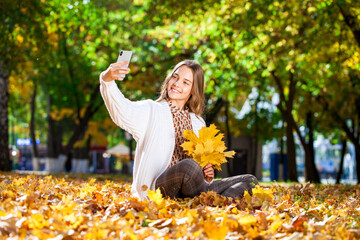 Blonde teenage girl posing in autumn park