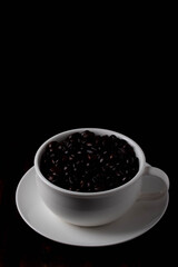 Coffee beans in a coffee cup on a wooden background