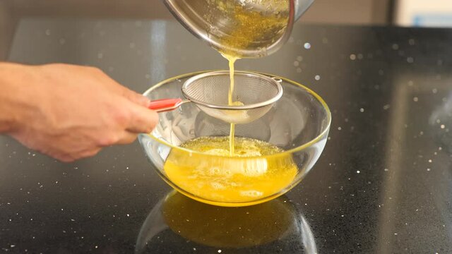 Straining boiled butter for cooking.