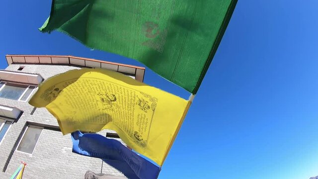 Buddhist flags blowing with wind on a hill top during broad daylight. old asian mountain village in Himachal Pradesh, near Shimla. Calm and soothing meditation area. Om mani padme hum.