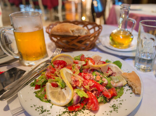 Fresh mixed tomato salad with beer and bread in a basket,Podgorica,Montenegro.