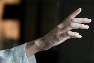 woman's hand reach out to grab something in the air.