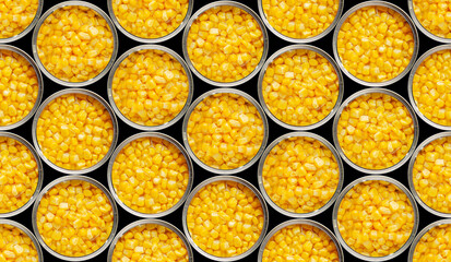 Seamless food background of flat lay view of opened tin cans with sweet corns isolated on black...