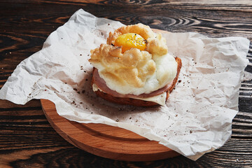 Bread with baked eggs Orsini and parsley leaves on a wooden stand