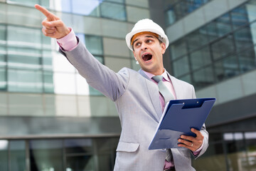 Businessman standing outdoor and emotionally pointing to something