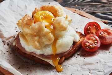 Bread with baked eggs Orsini and parsley leaves on a wooden stand