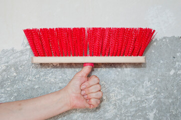 hand hold fetlock on gray grunge cement wall background. brush for repair and construction....