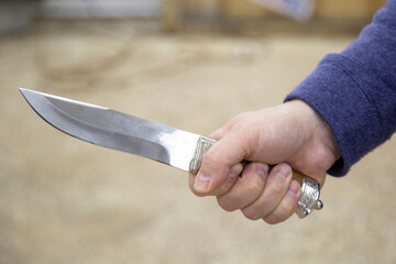 A man with a knife in his hands. Aggression and death threats.