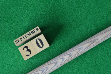 September 30, Number cube with a snooker stick on a green background, snooker table.