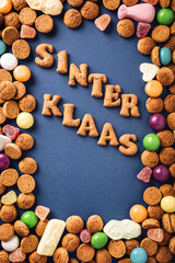 Dutch holiday Sinterklaas background with kruidnoten cookies and traditional hollands sweets. Concept for children party Saint Nicholas day five december with copy space. Top view, overhead.