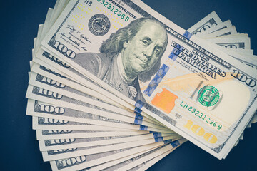 100 american dollars on black background