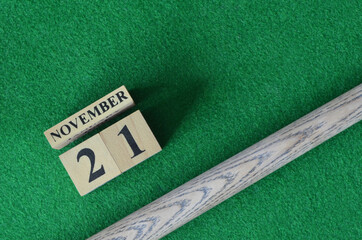 November 21, Number cube with a snooker stick on a green background, snooker table.