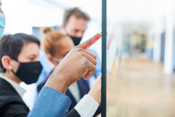 Hand von Business Mann zeigt auf Zettel mit Ideen