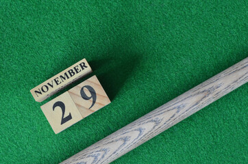 November 29, Number cube with a snooker stick on a green background, snooker table.