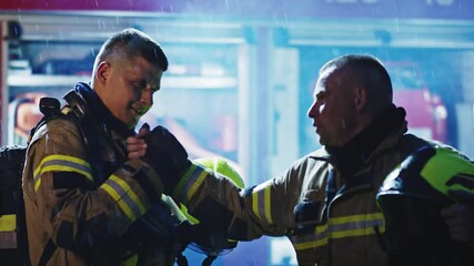 Two firefighters shaking hands after successfully extinguished fire. High quality 4k footage