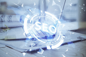 Multi exposure of table with computer and seo drawing hologram. Search optimization concept.