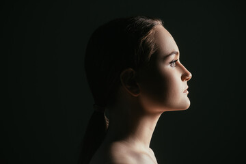 Face contouring. Aesthetic cosmetology. Profile portrait of confident woman isolated on black copy space background. Skincare wellness. Lip augmentation. © golubovy