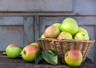 Healthy organic apples in a basket on a wooden background in the sunlight. The concept of a healthy diet.