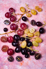 Fresh red, white and black grapes on a textured background