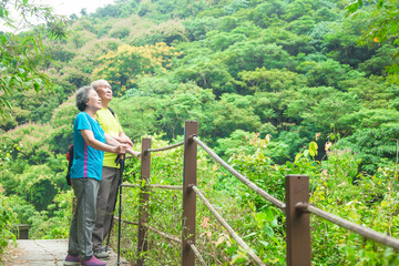 Fototapeta na wymiar senior couple hiking in nature park and looking up