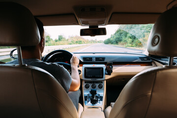 The young man driving the modern car on asphalt road