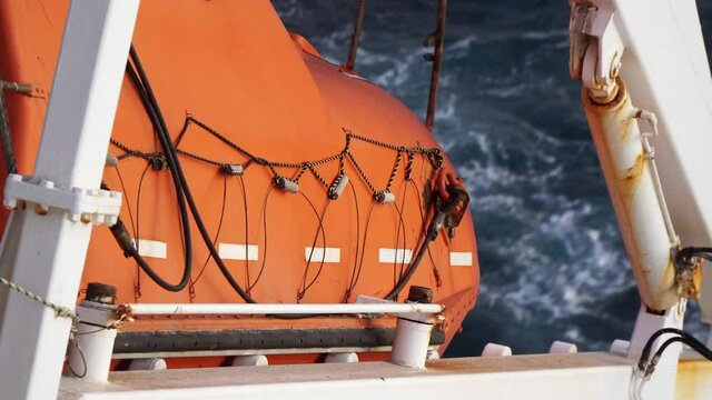Closeup view of orange color freefall lifeboat.