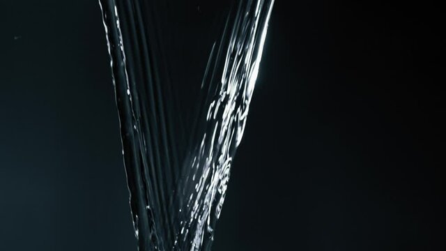 Clear Fluids Rapidly Poured Down. Texture And Its Motion In A Dark Background. - Close Up- Macro